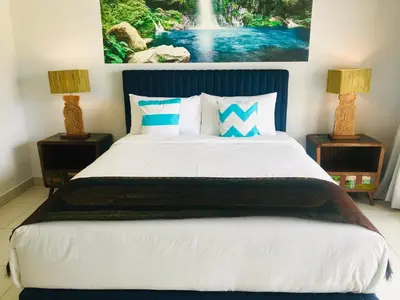 a bedroom with a large bed with two lamps at Villa Pintu Biru in Seminyak