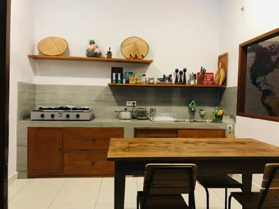 a kitchen with a wooden table and a sink at Villa Pintu Biru in Seminyak