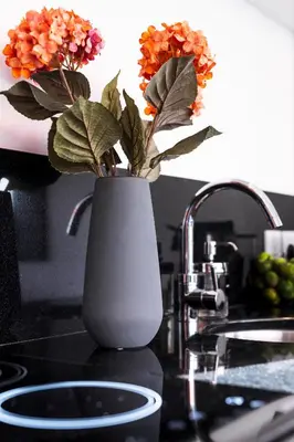 a white vase with flowers on a counter next to a sink at Villa Karang in Seminyak