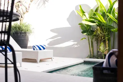 a patio with a pool and potted plants at Villa Karang in Seminyak