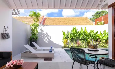 a living room with a patio with a table and chairs at Villa Chikka in Seminyak