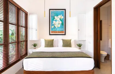 a bedroom with a large bed and a picture on the wall at Villa Chikka in Seminyak