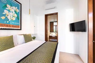 a hotel room with a bed and a tv at Villa Chikka in Seminyak