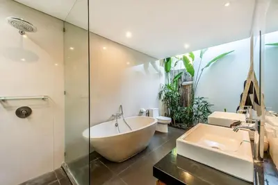 a bathroom with a large tub and a sink at Manis, Luxury 3 Bedroom Heart of Seminyak in Seminyak