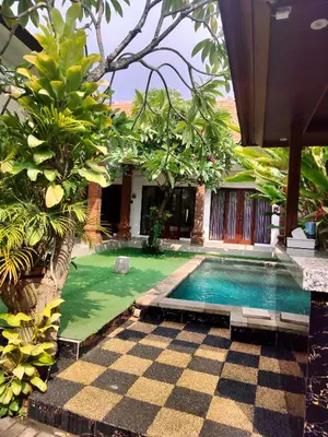 a swimming pool in a garden with a checkered floor at D&D homestay in Pesanggaran