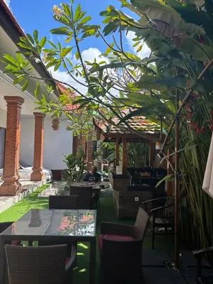 a restaurant with tables and chairs and plants at D&D homestay in Pesanggaran