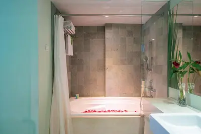 a bathroom with a bath tub and a sink at EDEN Hotel Kuta Bali in Kuta