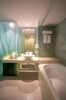 a bathroom with a sink and a bath tub at EDEN Hotel Kuta Bali in Kuta