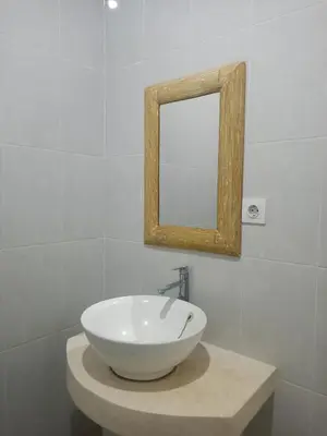 a bathroom with a bowl sink and a mirror at Adijaya homestay in Seminyak