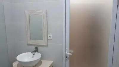 a white bathroom with a sink and a mirror at Adijaya homestay in Seminyak