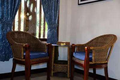 two wicker chairs and a table in a room at Puri Cendana Resort Bali in Seminyak