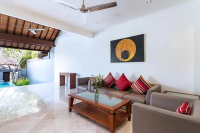 a living room with a couch and a table at Villa Lalang Temu in Jimbaran
