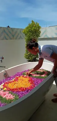 a woman reaching into a large tub filled with flowers at Villa Capil in Seminyak