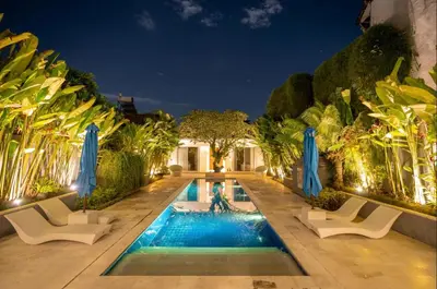 a villa with a swimming pool at night at Villa Capil in Seminyak