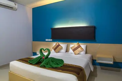a bedroom with a bed with two swans on it at Bakung Beach Resort in Kuta