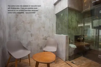 two chairs and a table in front of a bathroom at Bali Breezz Hotel in Jimbaran