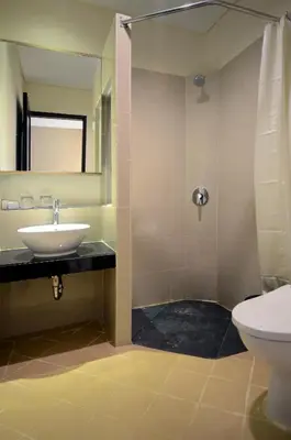 a bathroom with a sink and a toilet at Bali Breezz Hotel in Jimbaran