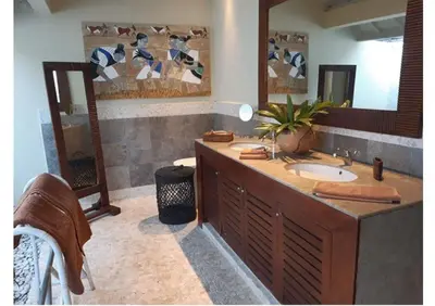 a bathroom with a sink and a large mirror at Villa Sukapadi in Seminyak