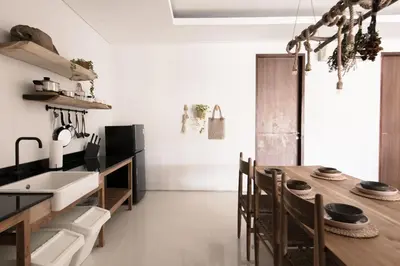 a kitchen with a sink and a wooden table at Pelangi 148 Beach Suites in Seminyak