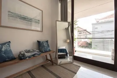 a room with a mirror and a bench and a window at Pelangi 148 Beach Suites in Seminyak