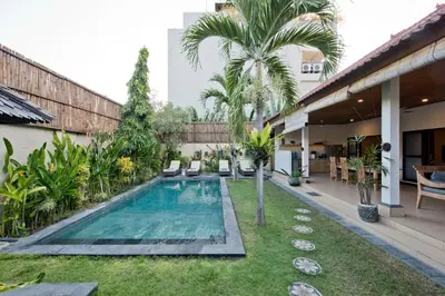 a courtyard with a swimming pool and a yard at Villa Star in Seminyak