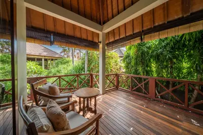 a porch with chairs and tables on a wooden deck at Villa Rubina - Luxury Pool Villa in Batu Belig Next to the Beach! in Seminyak