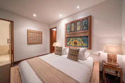 a bedroom with a bed and a painting on the wall at Villa Rubina - Luxury Pool Villa in Batu Belig Next to the Beach! in Seminyak