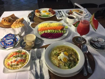 a table with plates of food on a table at Hevea Villas in Seminyak