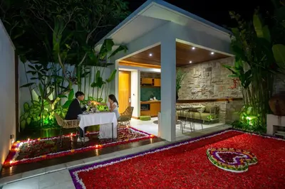 a man and woman sitting at a table in a house at Bali Vilaasee in Seminyak