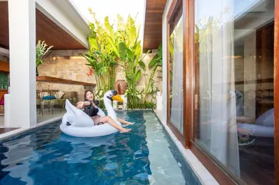 a woman sitting on an inflatable pool in a house at Bali Vilaasee in Seminyak