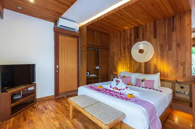 a bedroom with a large bed and a flat screen tv at Bali Vilaasee in Seminyak