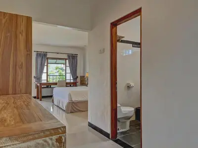 a bedroom with a bed and a bathroom with a toilet at Sanur Lodge in Sanur