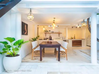 a kitchen and dining room with a wooden table and chairs at Ocean Luxury Villas - Private Pool Seminayk in Seminyak