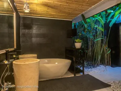 a bathroom with a bath tub and a large window at Ocean Luxury Villas - Private Pool Seminayk in Seminyak