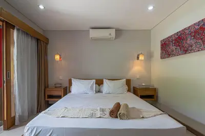 a bedroom with a bed with towels on it at Balinea Holiday Home in Kerobokan