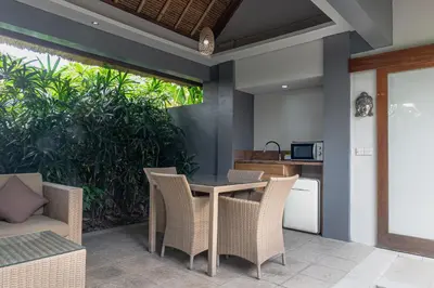 an outdoor dining area with a table and chairs at Balinea Holiday Home in Kerobokan