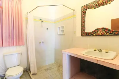 a bathroom with a toilet and a sink and a mirror at Sari Bali Resort in Kuta