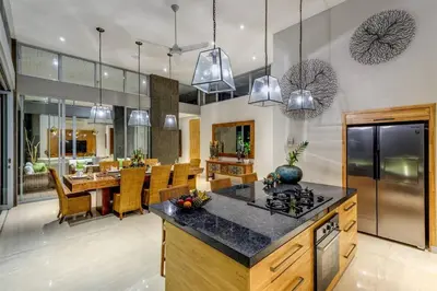 an open kitchen and dining room with pendant lights at Aramanis in Seminyak
