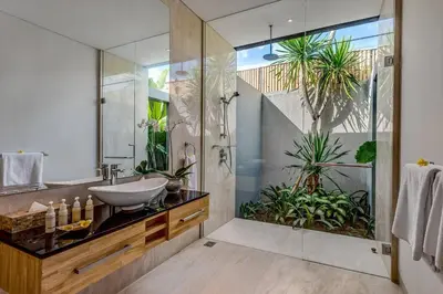 a bathroom with a sink and a shower with plants at Aramanis in Seminyak