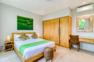 a bedroom with a large bed and a desk at Aramanis in Seminyak
