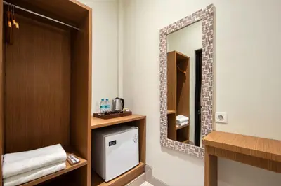 a small bathroom with a mirror and a sink at Angkul Angkul Segara Beach Kuta by Kamara in Kuta