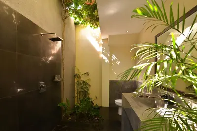 a bathroom with a shower with plants in it at Elok Villas in Seminyak