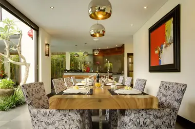 a dining room with a wooden table and chairs at Elok Villas in Seminyak