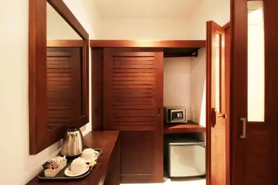 a small kitchen with a wooden door and a table at Letos Kubu Homestay in Kuta