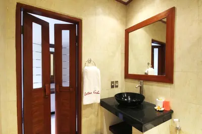 a bathroom with a black sink and a mirror at Letos Kubu Homestay in Kuta