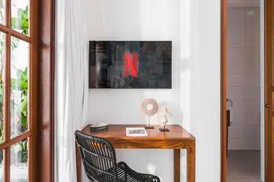 a room with a wooden table with a x on the wall at Villa Salsa in Seminyak