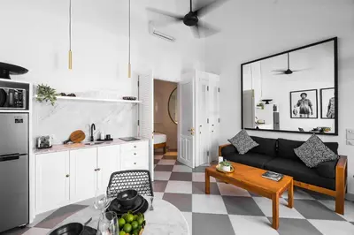 a living room with a black couch and a kitchen at Villa Chino in Seminyak