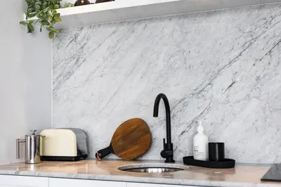 a kitchen counter with a sink with a cutting board at Villa Chino in Seminyak