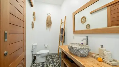 a bathroom with a sink and a toilet at Villa Umara by Villa Finder in Seminyak