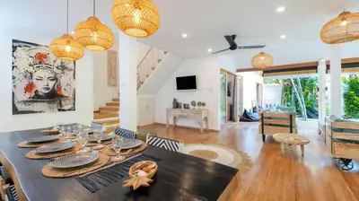 a dining room and living room with a table at Villa Umara by Villa Finder in Seminyak